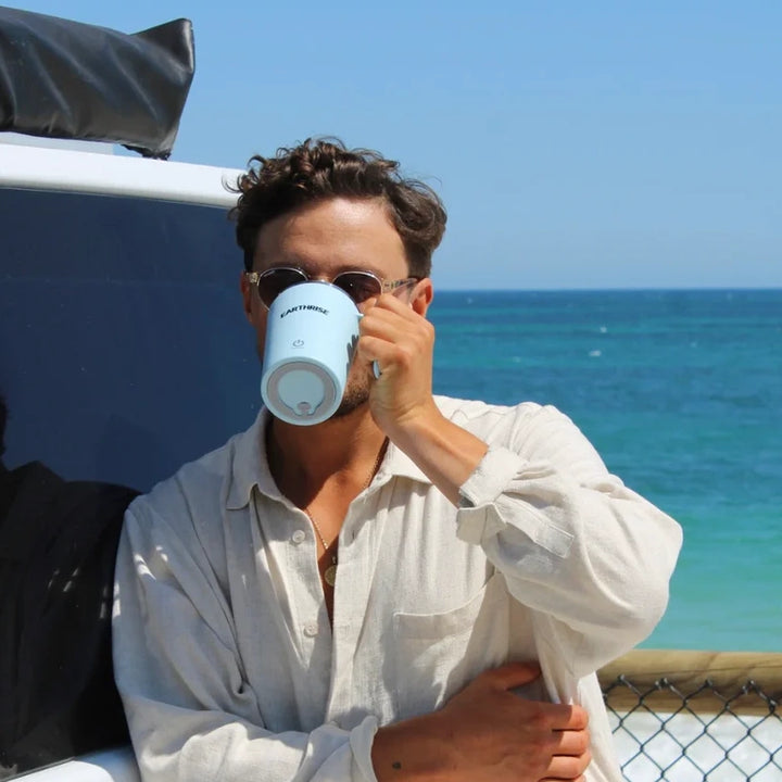 A person drinking from a mug of Earthrise coffee alternative