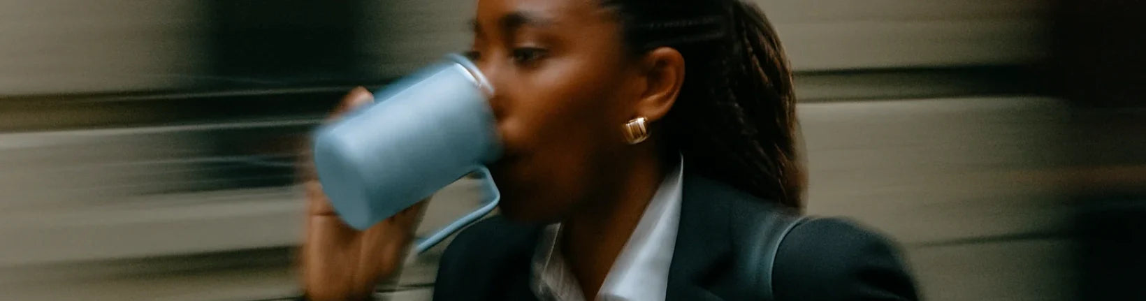A busy professional person running through a crowded street sipping on Earthrise coffee alternative