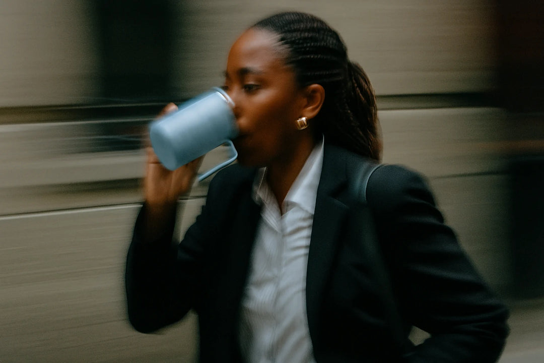 A person drinking a cup of Earthrise on their way to work