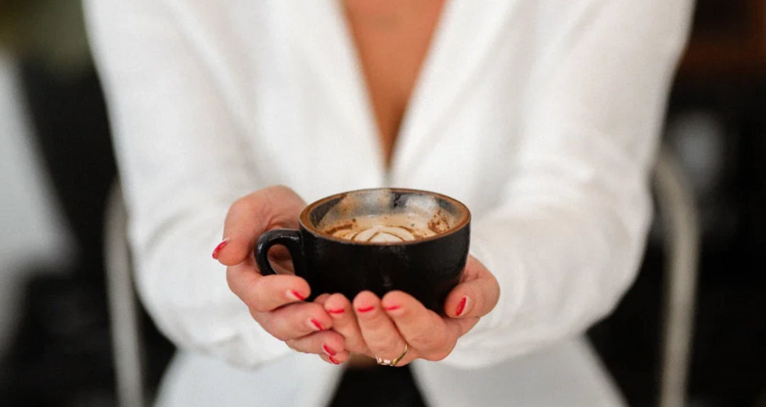 A woman holding a mug of Earthrise coffee alternative
