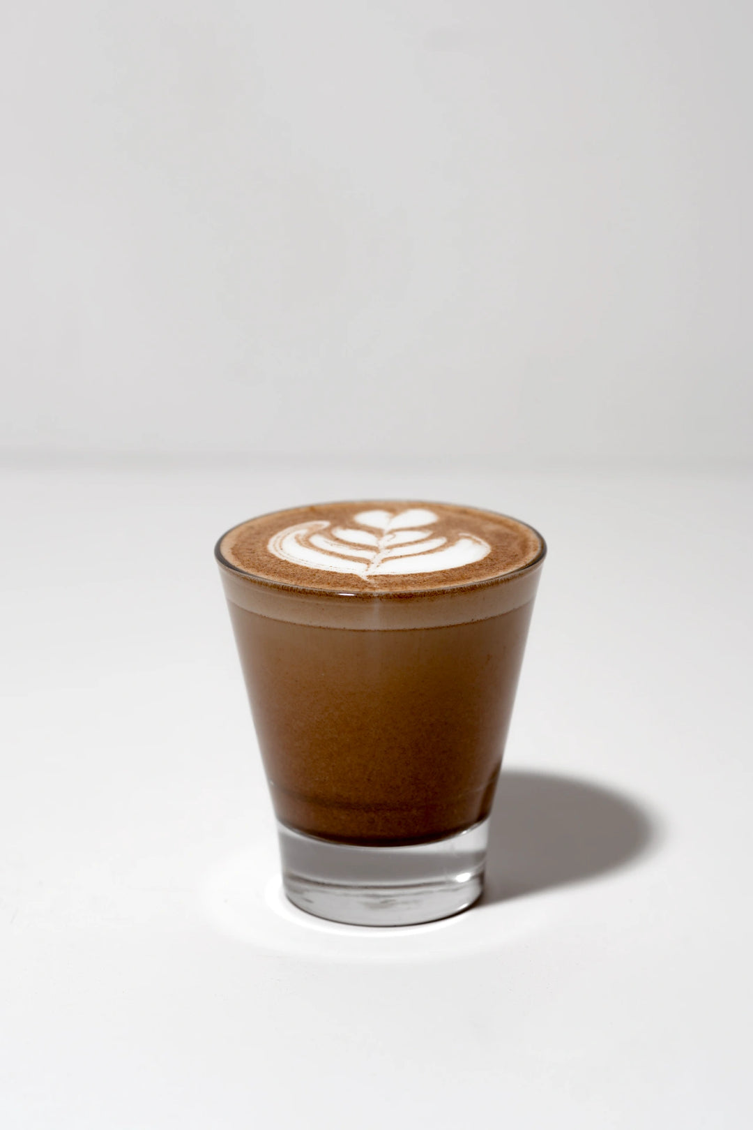 A fresh brew of Earthrise coffee alternative in a glass cup on a plain background